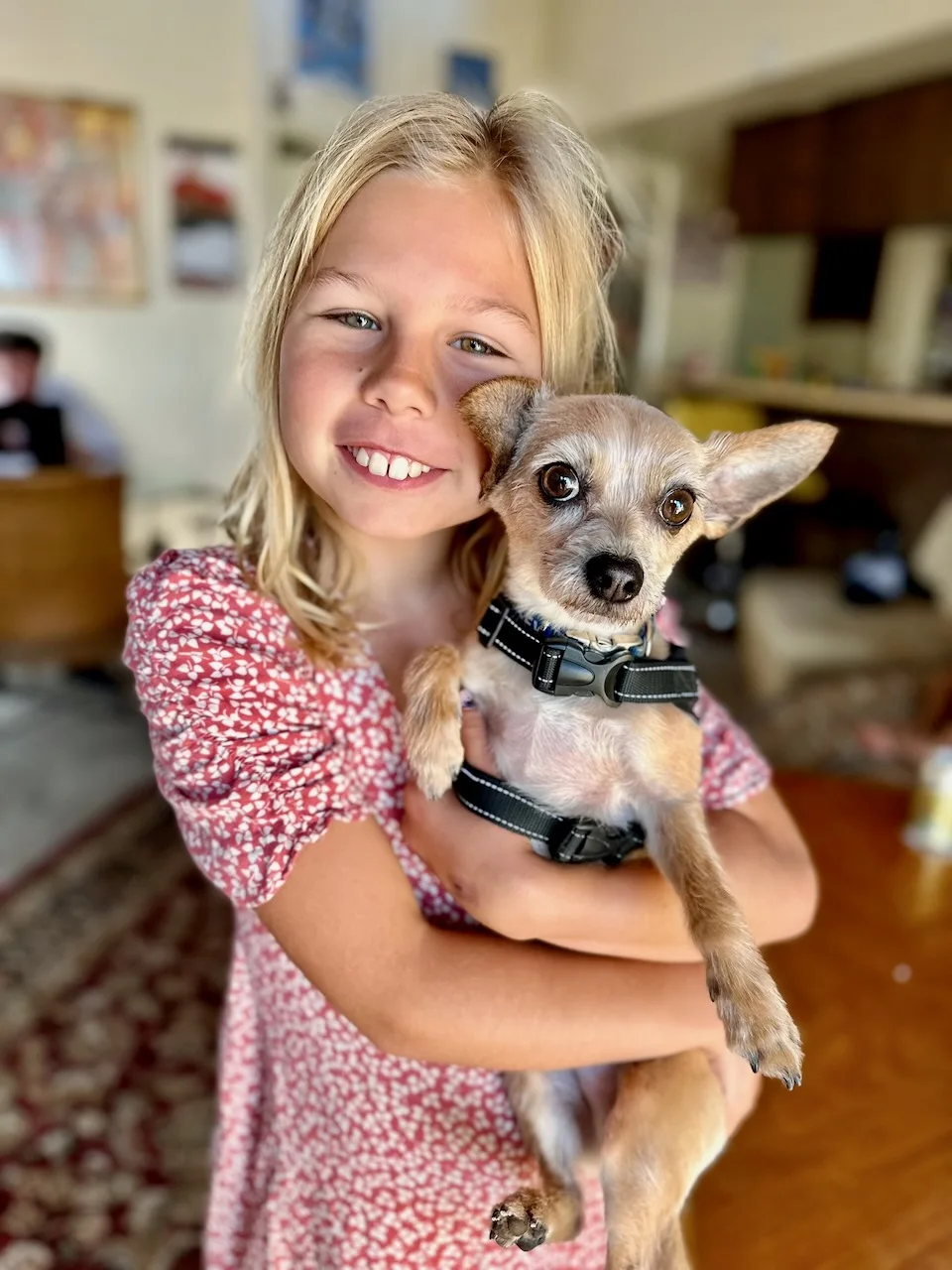 Ivy smiling while holding a small dog